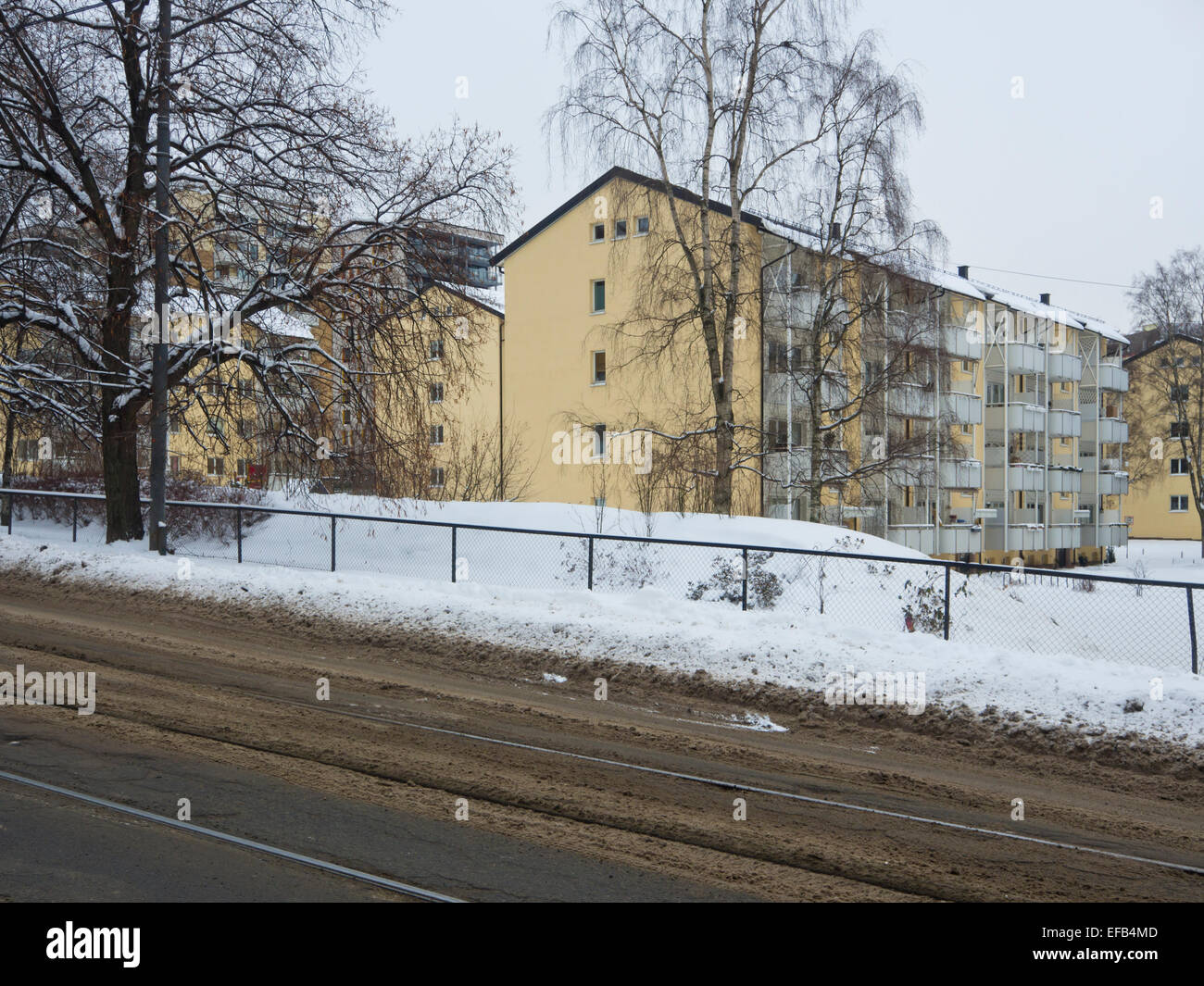 Oslo in wintertime, yellow apartment blocks street with muddy snow and tram tracks (Storo / Sandaker) Stock Photo