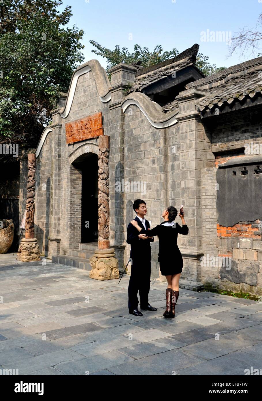 Chengdu, China:  Young couple talking outside a finely restored 18th century home on Zhai Alley in Old Town Stock Photo