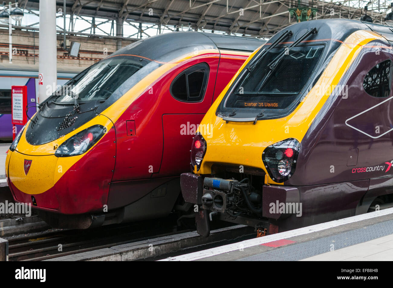 Virgin trains Pendolino and Cross Country Voyager high speed trains side by side at Manchester Piccadilly railway station Stock Photo