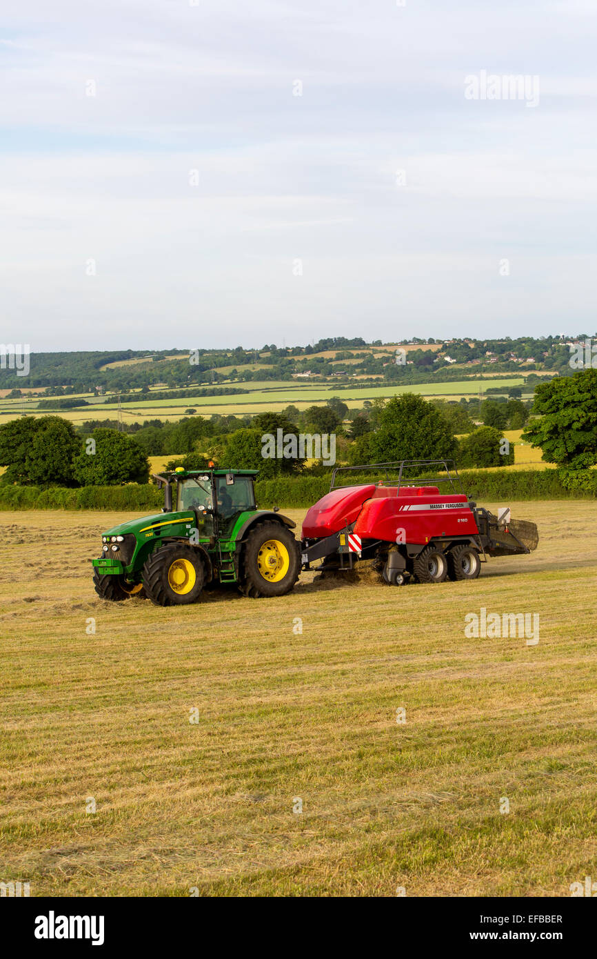 Tractor and hay baling baling hay in field, Oxfordshire, England Stock Photo