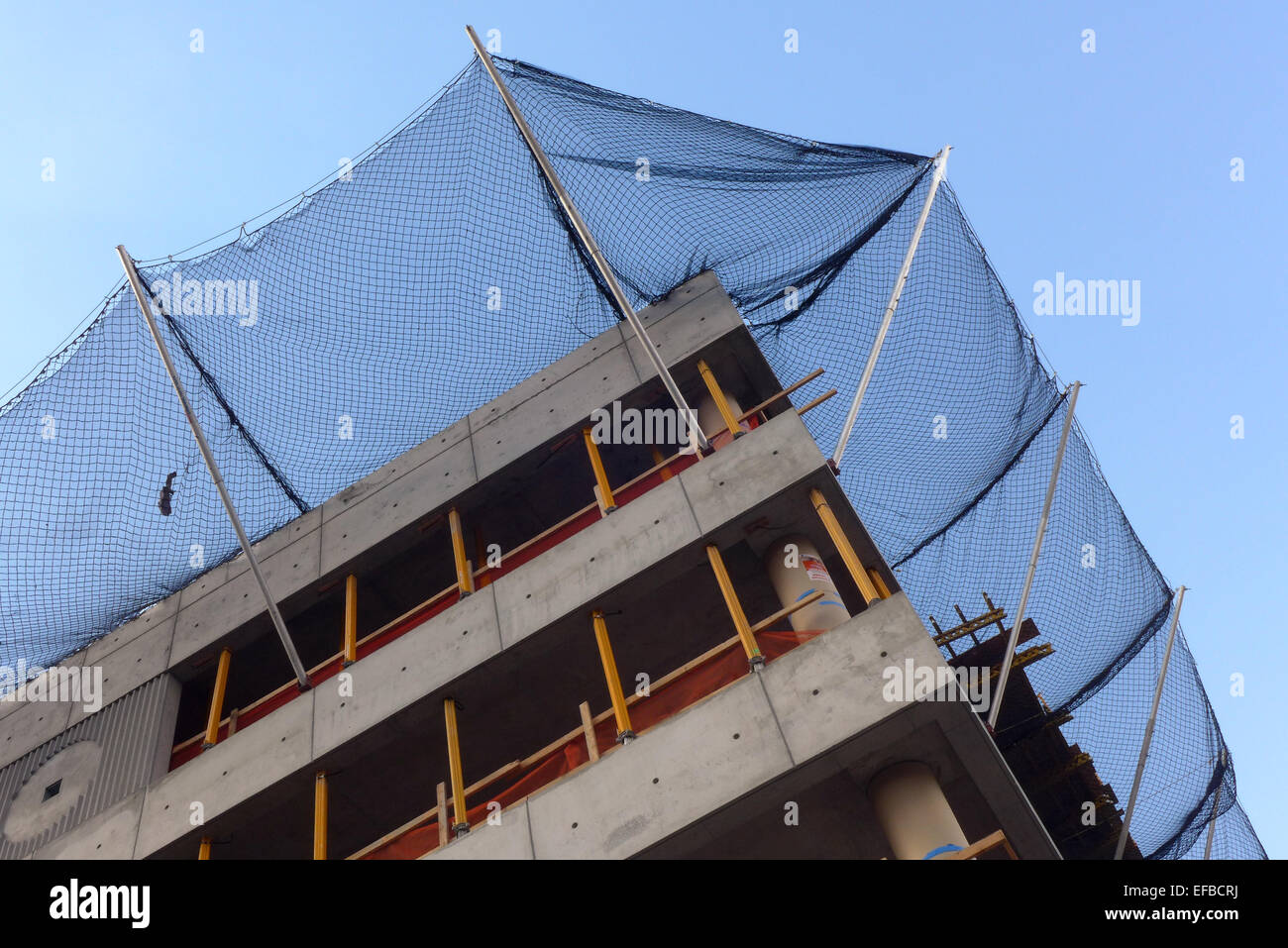 Construction of a building in Lower Manhattan with a safety  net against a blue sky., as seen from the High Line. Stock Photo