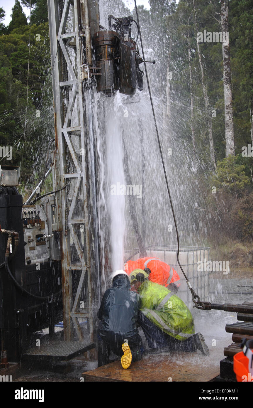 MOANA, NEW ZEALAND, MARCH 18, 2010: Drilling crewmen control a blowout at the mouth of a well for coal seam  gas near Moana Stock Photo