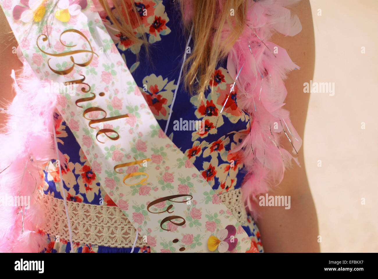 A bride to be wearing a hen party sash and feather boa Stock Photo