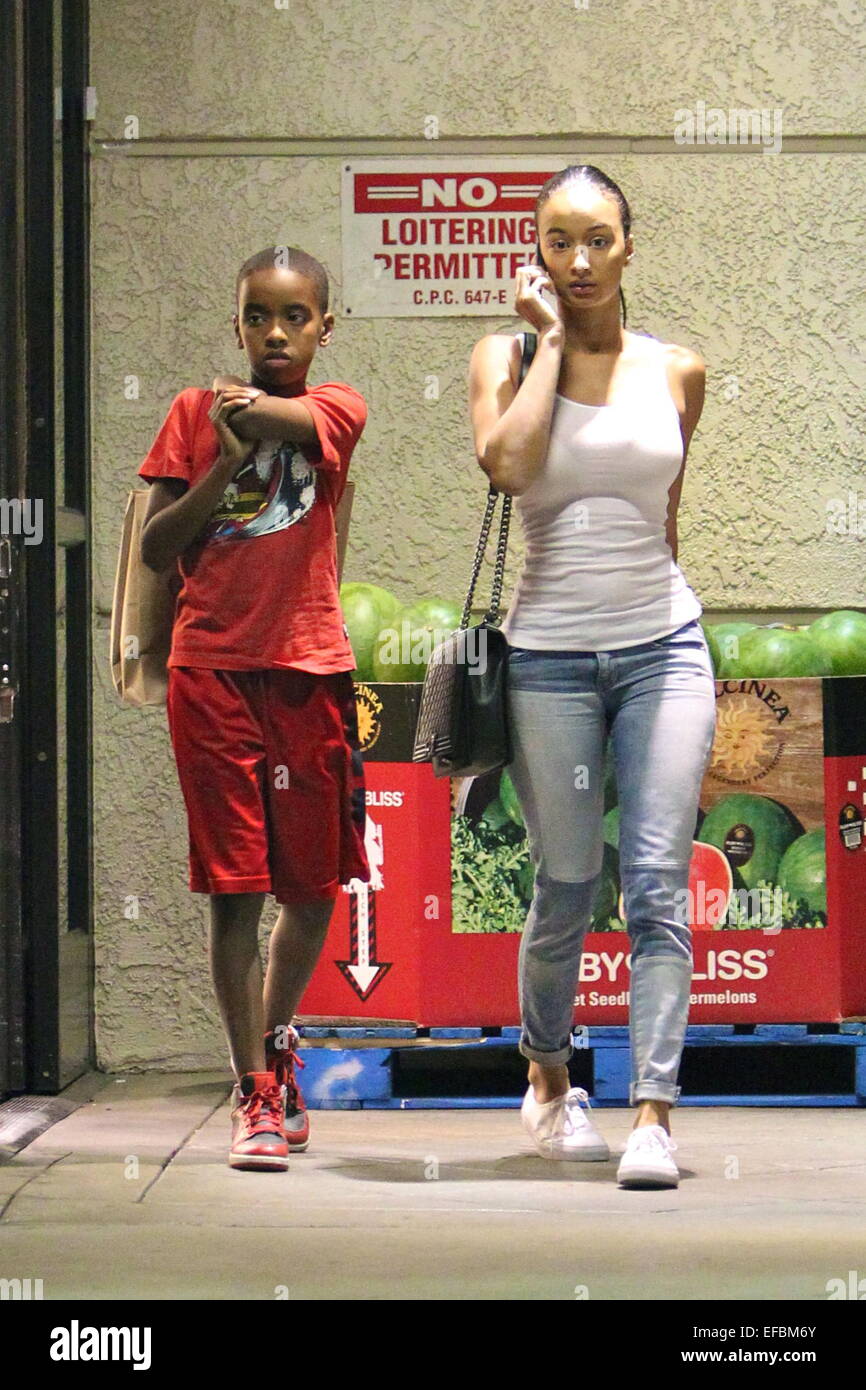Draya Michele has her hands full juggling taking a call on her cell phone,  carrying a Chanel handbag while buying wine and pink champagne at Gelsons  Supermarket Featuring: Draya Michele,Kniko Arenas Where: