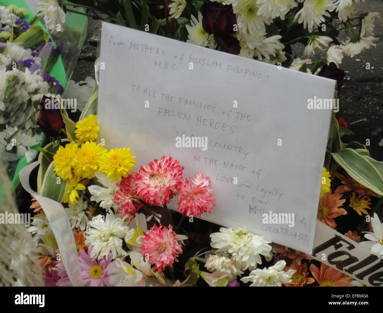 A postcard written by Filipino Muslim mothers expressing their condolences sits on top of a flower bouquet outside the Philippine National Police headquarters. Philippine President Benigno Aquino III declared a National Day of Mourning to commemorate the 44 elite commandos who were slain in an encounter at Mamasapano, Maguindanao province. © Richard James Mendoza/Pacific Press/Alamy Live News Stock Photo