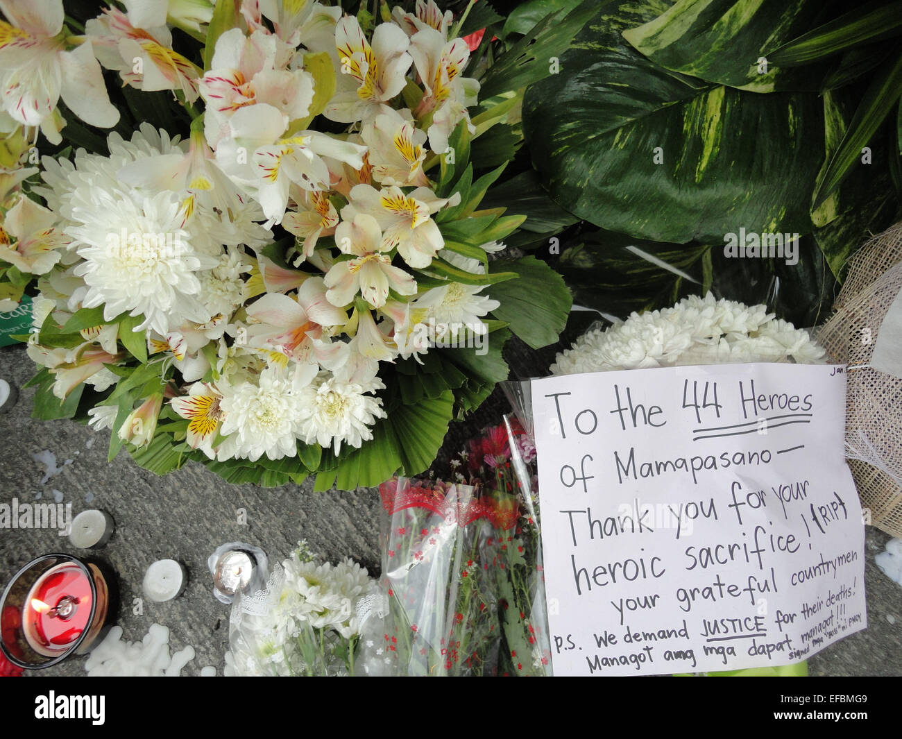 Flowers, candles, and a postcard are among the items that lay outside the Philippine National Police headquarters. Philippine President Benigno Aquino III declared a National Day of Mourning to commemorate the 44 elite commandos who were slain in an encounter at Mamasapano, Maguindanao province. © Richard James Mendoza/Pacific Press/Alamy Live News Stock Photo