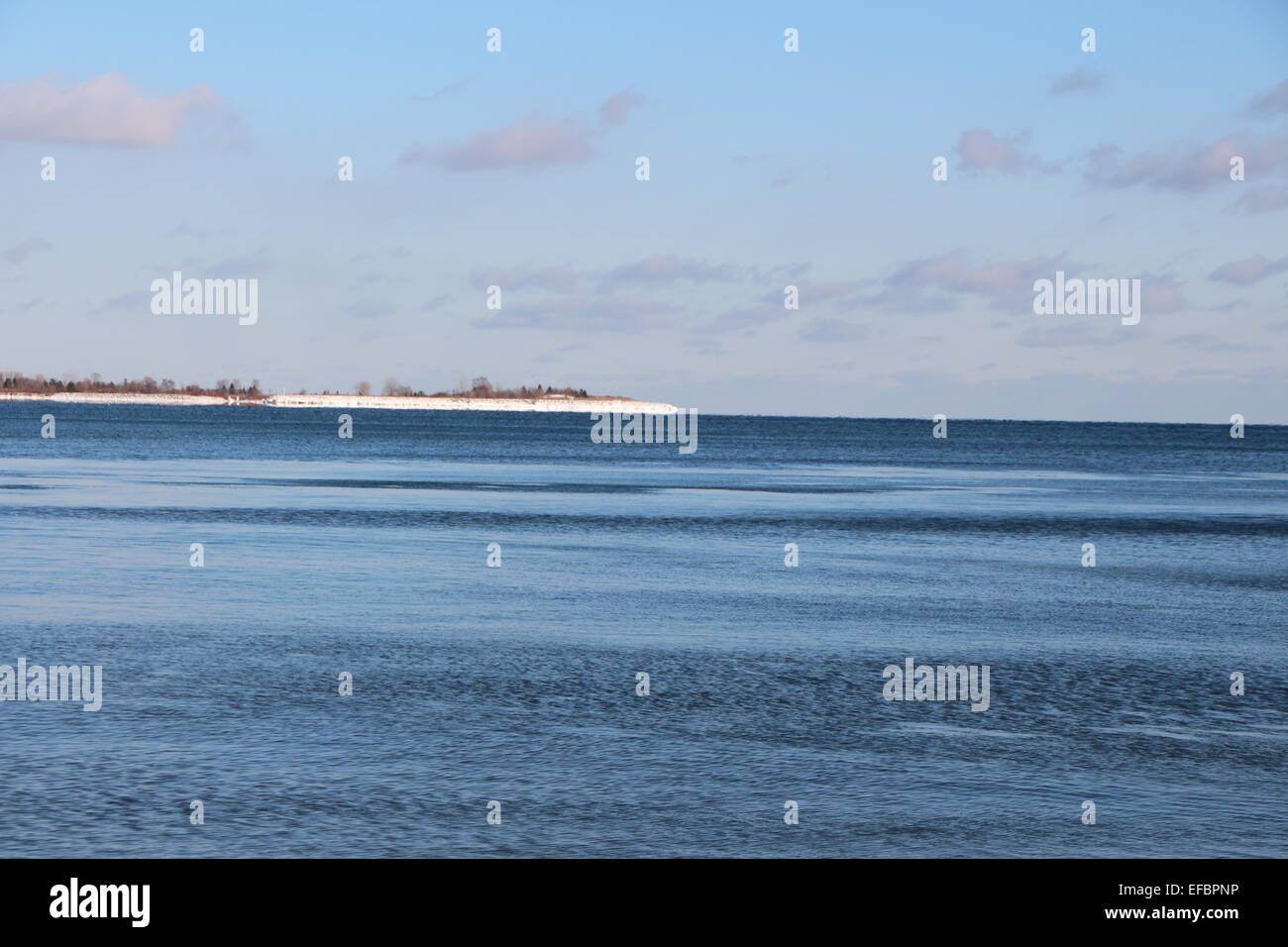 A windy day looking out at lake Ontario,with a blue sky with some clouds.wind is rippling the lake water. Stock Photo