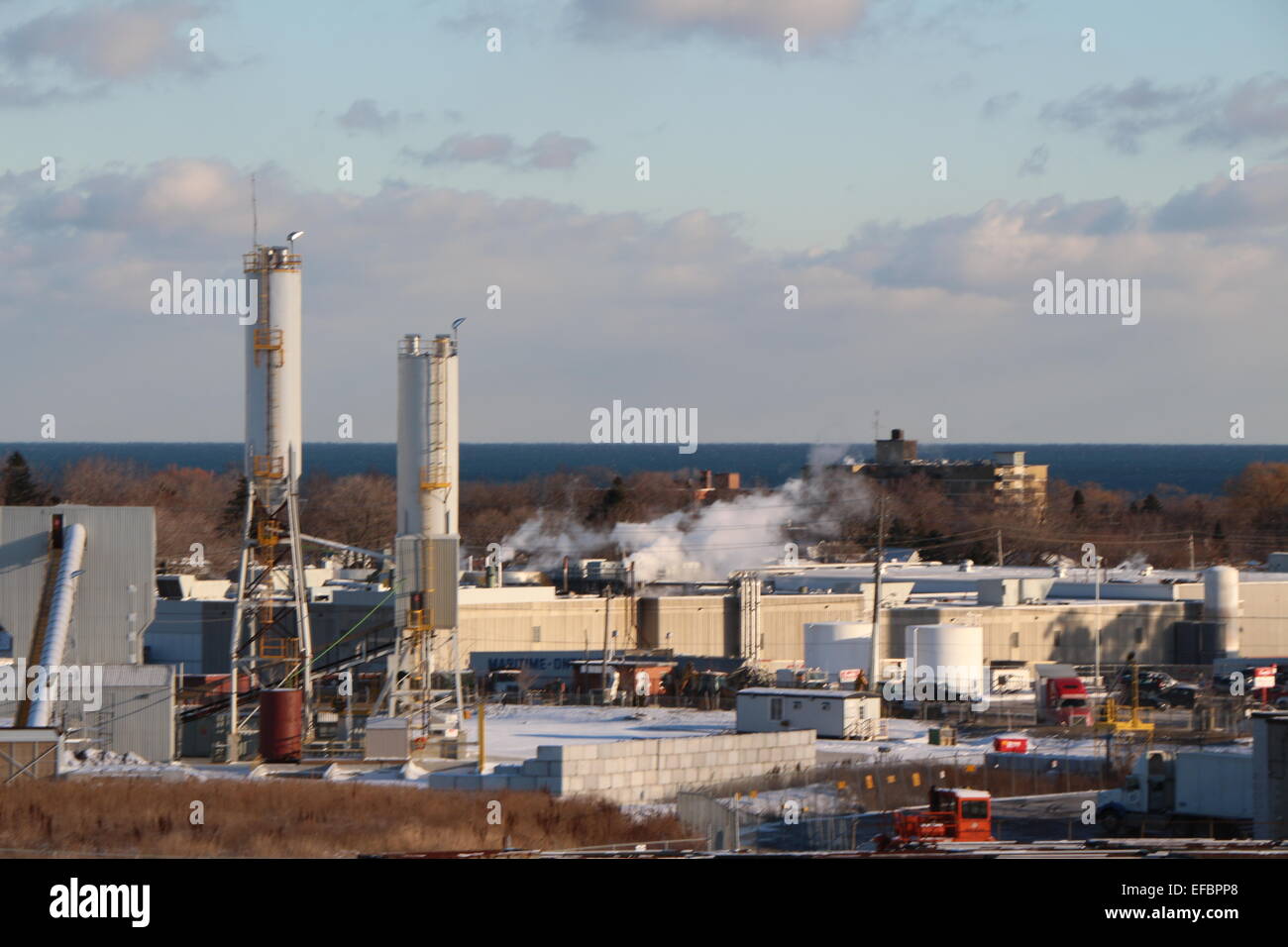 A large scale industry photo with lake in the background.factory photo.sky with clouds.production,factory and blue sky,industry Stock Photo