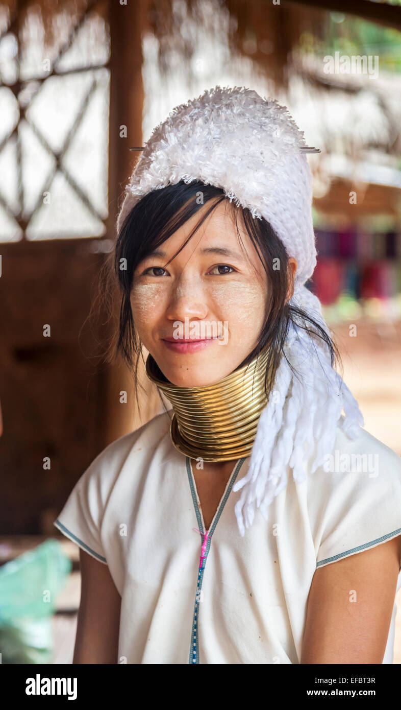 Smiling pretty young Burmese long neck woman wearing a white hat, in Karen Padong village near Chiang Rai, Thailand Stock Photo