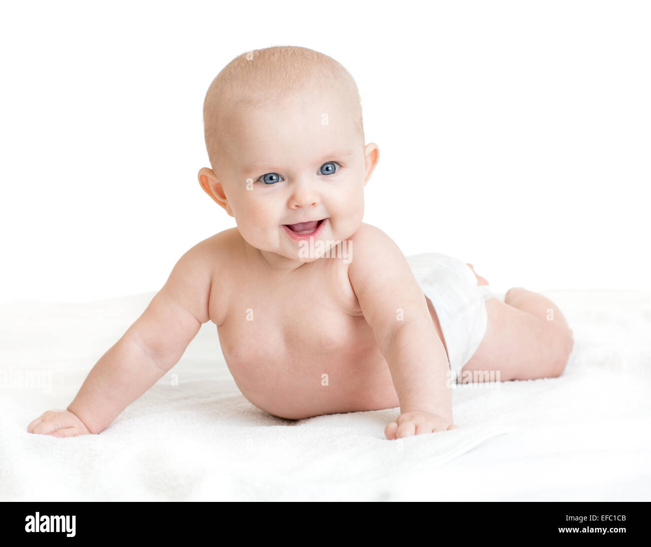 Cute smiling baby lying on white towel in nappy Stock Photo