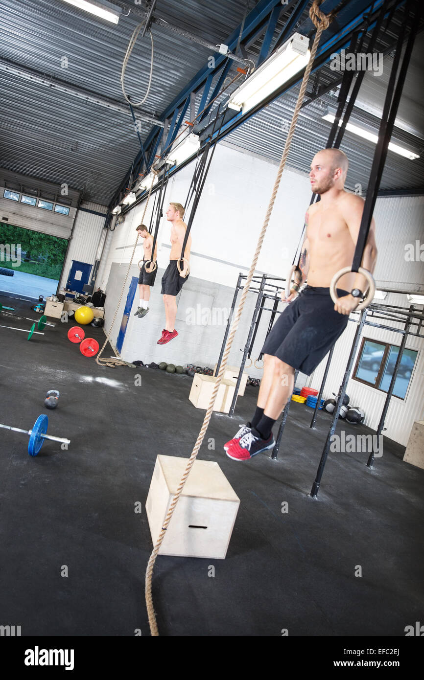 Three shirtless men exercise dips with rings Stock Photo Alamy