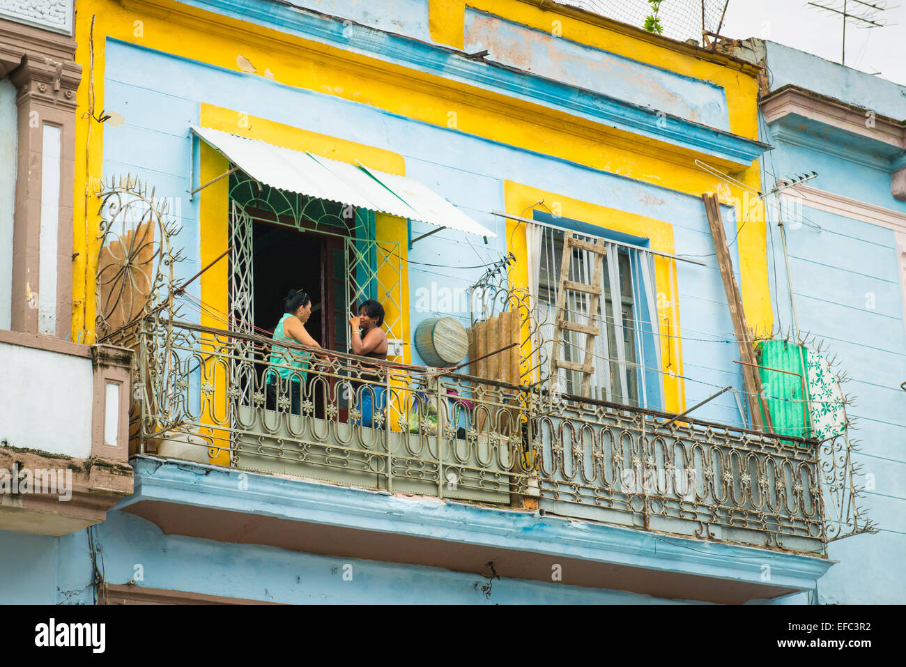 Cuba Old Havana La Habana Vieja typical apartment block of flats balcony balconies 2 lady ladies women chat talk on balcony Stock Photo