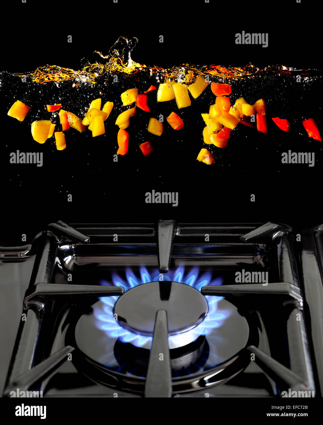 A conceptual image of carrots and swede being dropped into boiling water, shown over a gas hob; with space for text Stock Photo