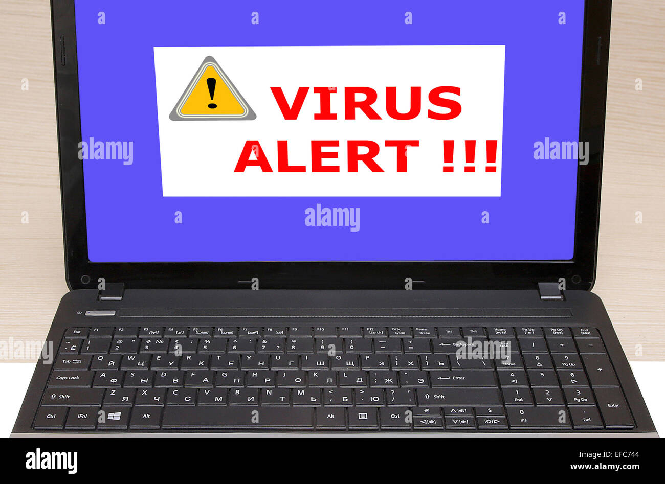 laptop with message on screen says virus alert Stock Photo