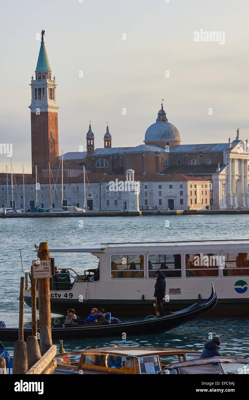 Boat water taxi and a gondola on Venice Lagoon with the church and island of San Giorgio Maggiore in background Veneto Italy Stock Photo