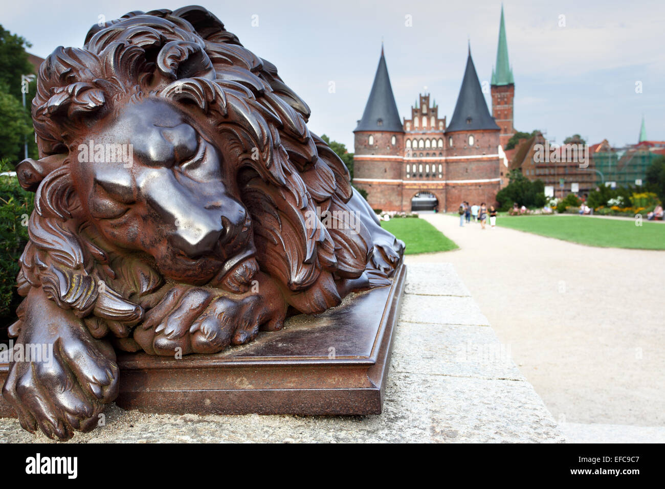 Sleeping lion and Holsten Gate, Lubeck, Germany Stock Photo