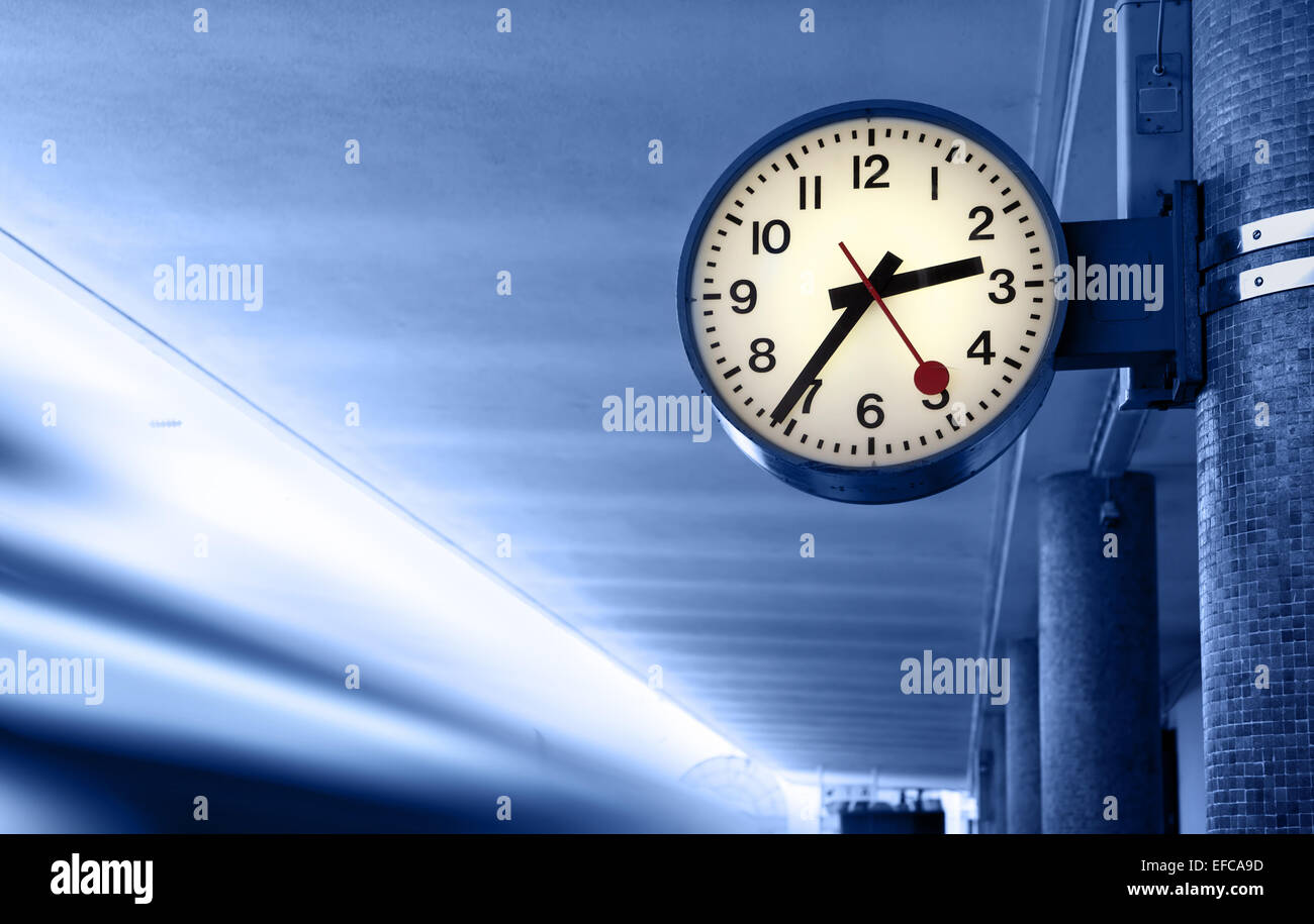 Clock at railway station. Toned in blue color. Stock Photo