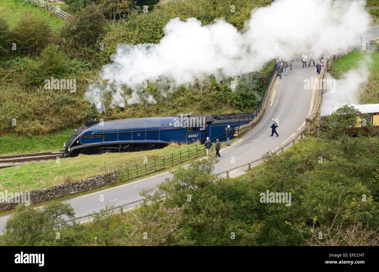Class A4 Pacific No 60007 'Sir Nigel Gresley' passing under the road bridge as it leaves Goathland station. Stock Photo