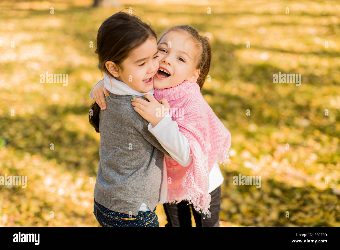 Cute little girls in the autumn park Stock Photo - Alamy
