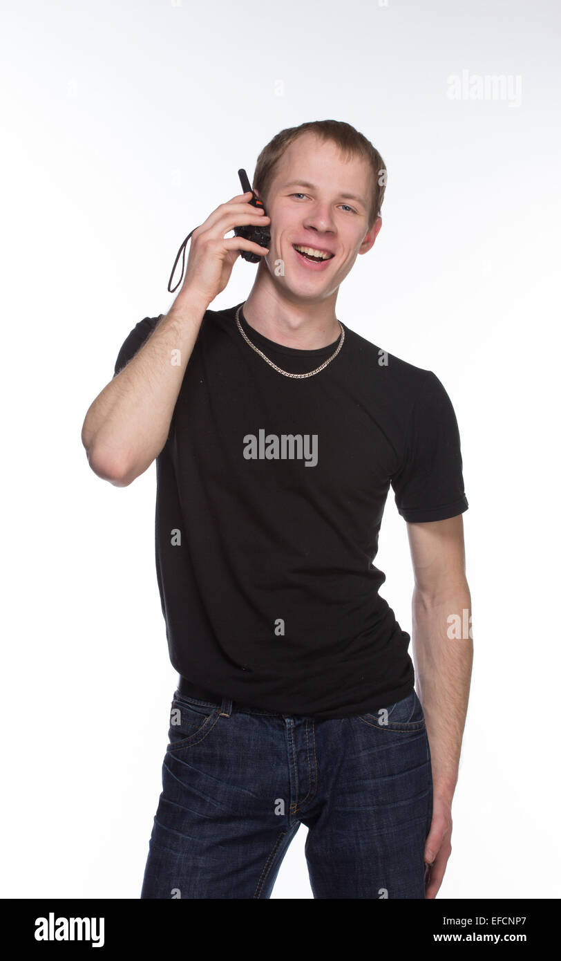 Young security officer talking through his walkie talkie. Isolated on white background. Half length portrait. Stock Photo