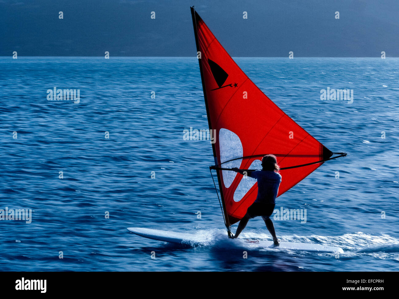The photographer panned his camera to follow a windsurfer who is skimming over the blue ocean along the coast of Southern California, USA. Stock Photo