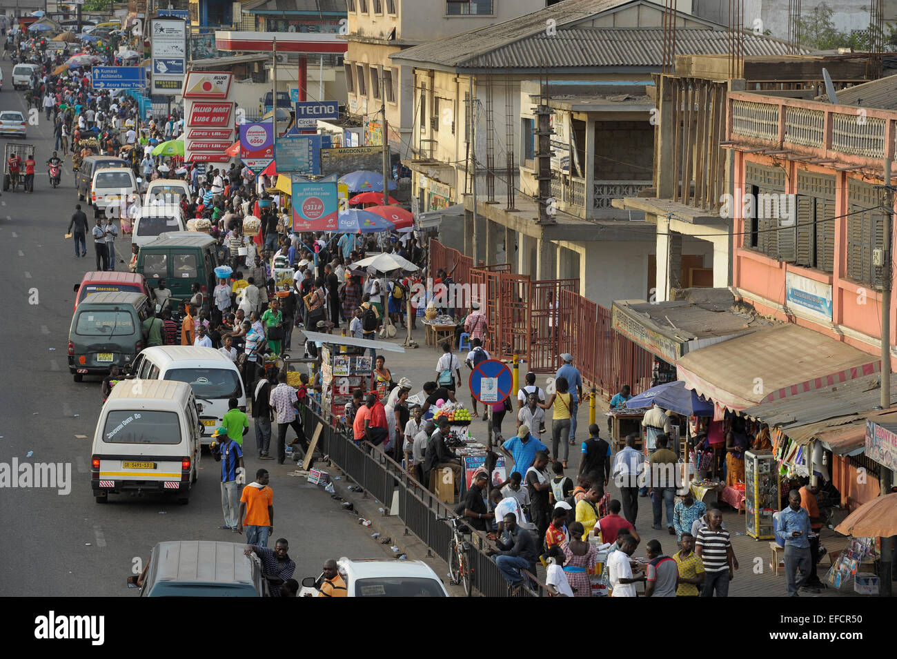 Pedestrians and traffic mix along one of Accra, Ghana's main thoroughfares. Stock Photo