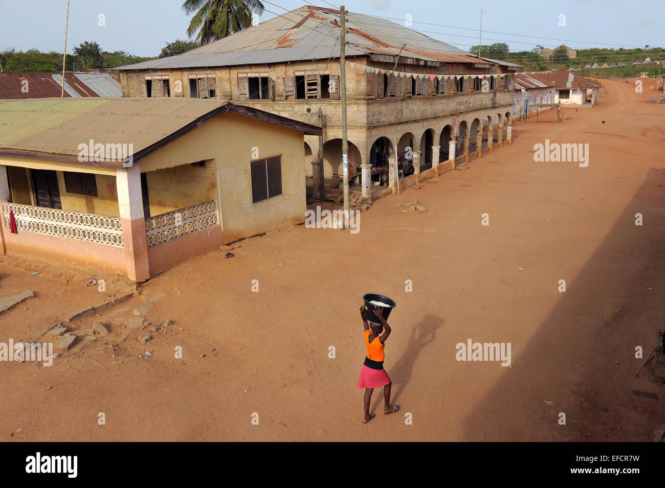 A girl walks down the main thoroughfare of Kweikrom, Ghana, West Africa. Stock Photo