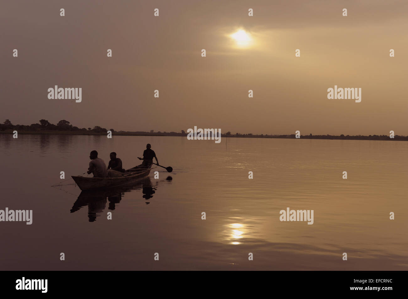 Fishermen ply the waters of Ghana's Lake Volta at dawn. Stock Photo