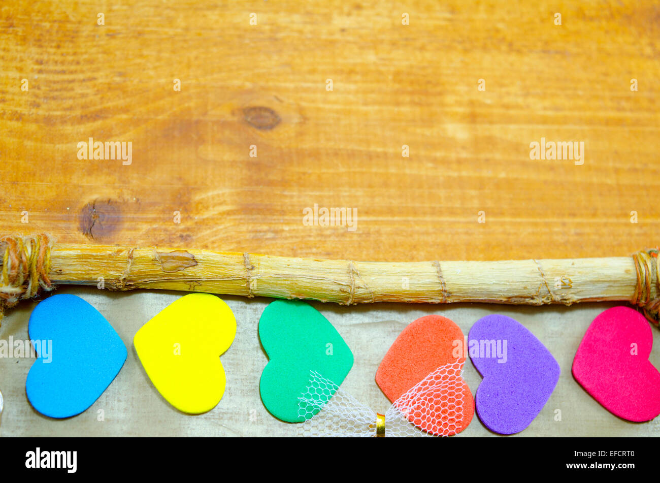 Bunch of colorful hearts on the edge of a wooden picture frame Stock Photo