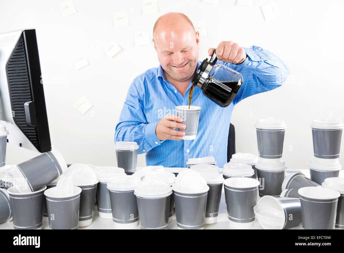 Smiling businessman drinks too much coffee Stock Photo