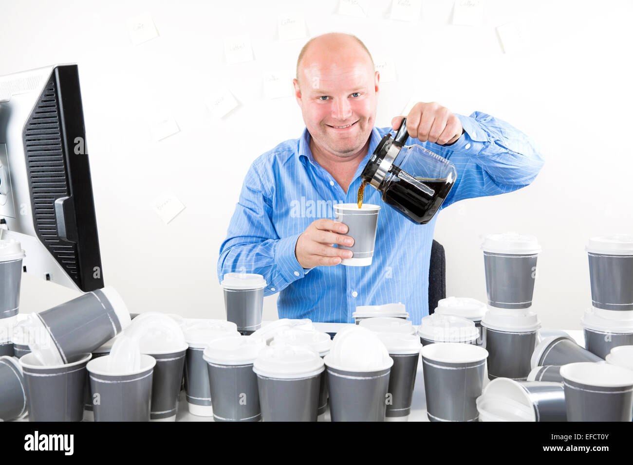 Happy office worker drinks too much coffee Stock Photo