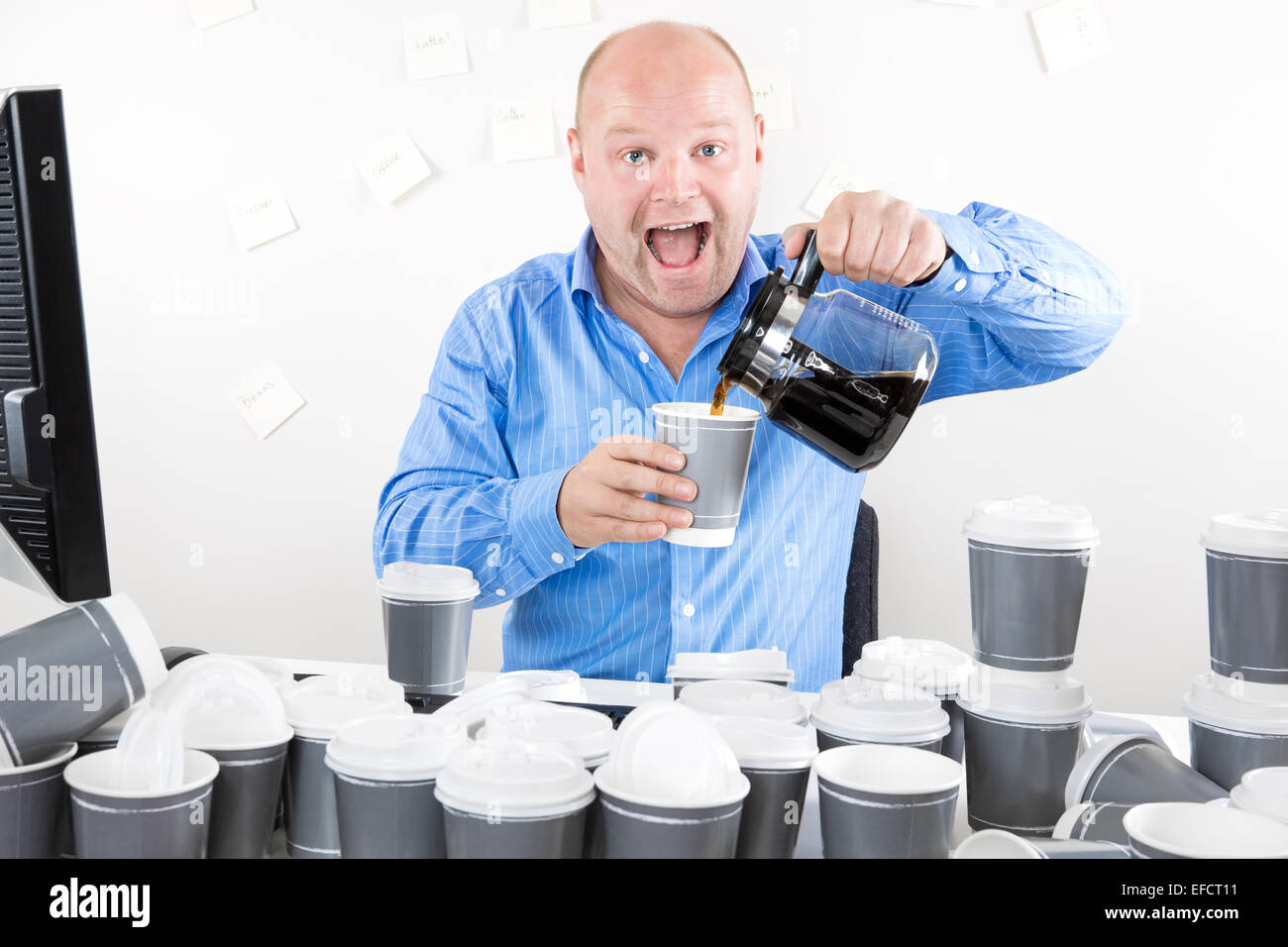 Happy businessman drinks way too much coffee Stock Photo