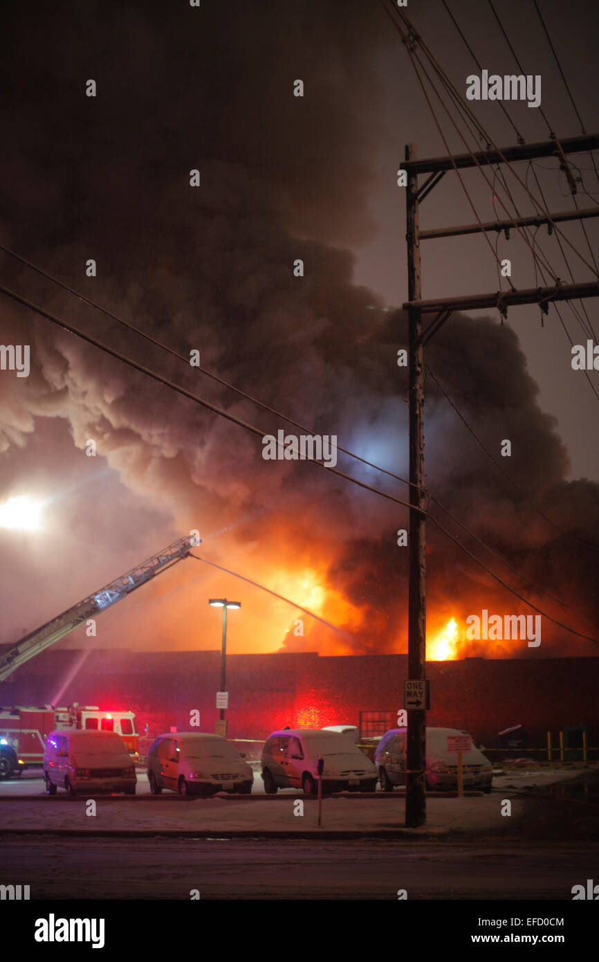 Smoke and flames on the roof of a burning building. Stock Photo