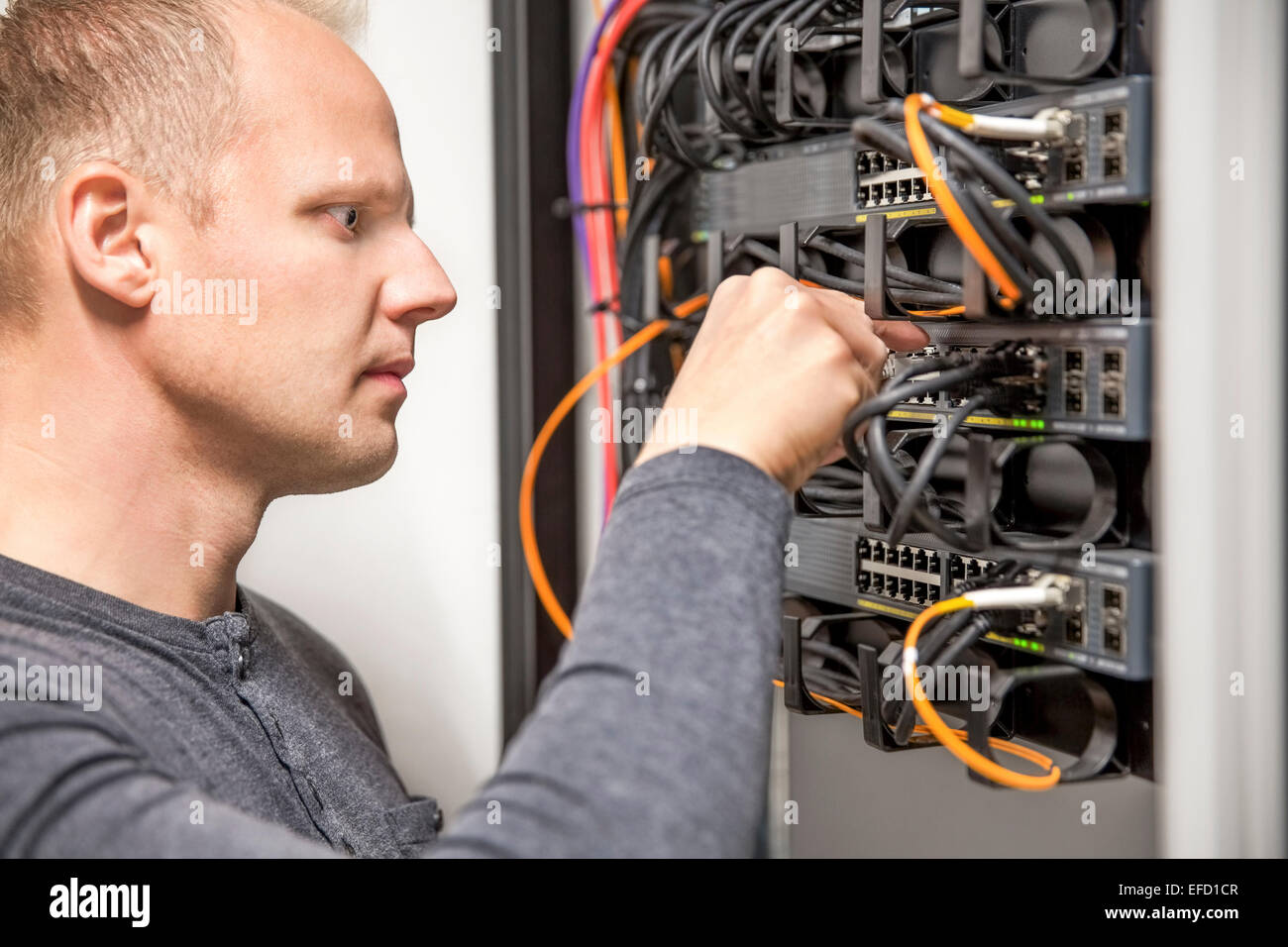 IT consultant connecting network cable into switch Stock Photo