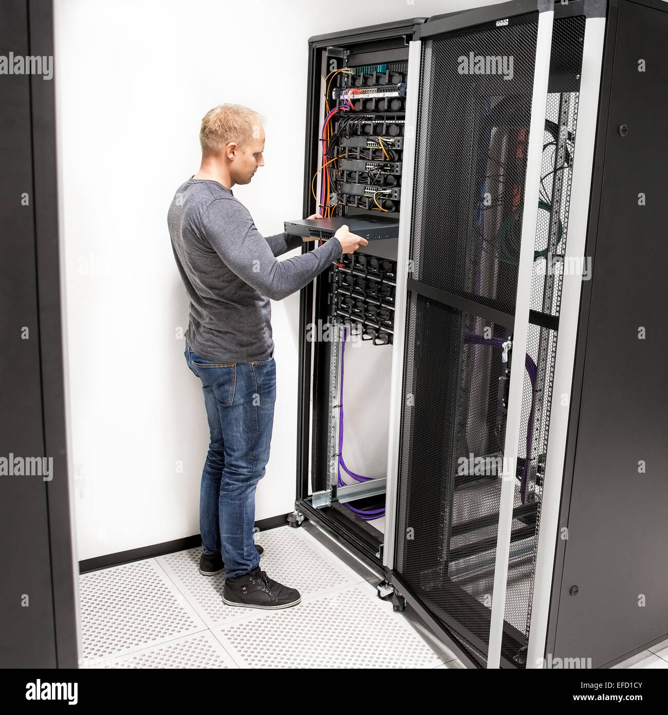 IT technician install network rack in datacenter Stock Photo