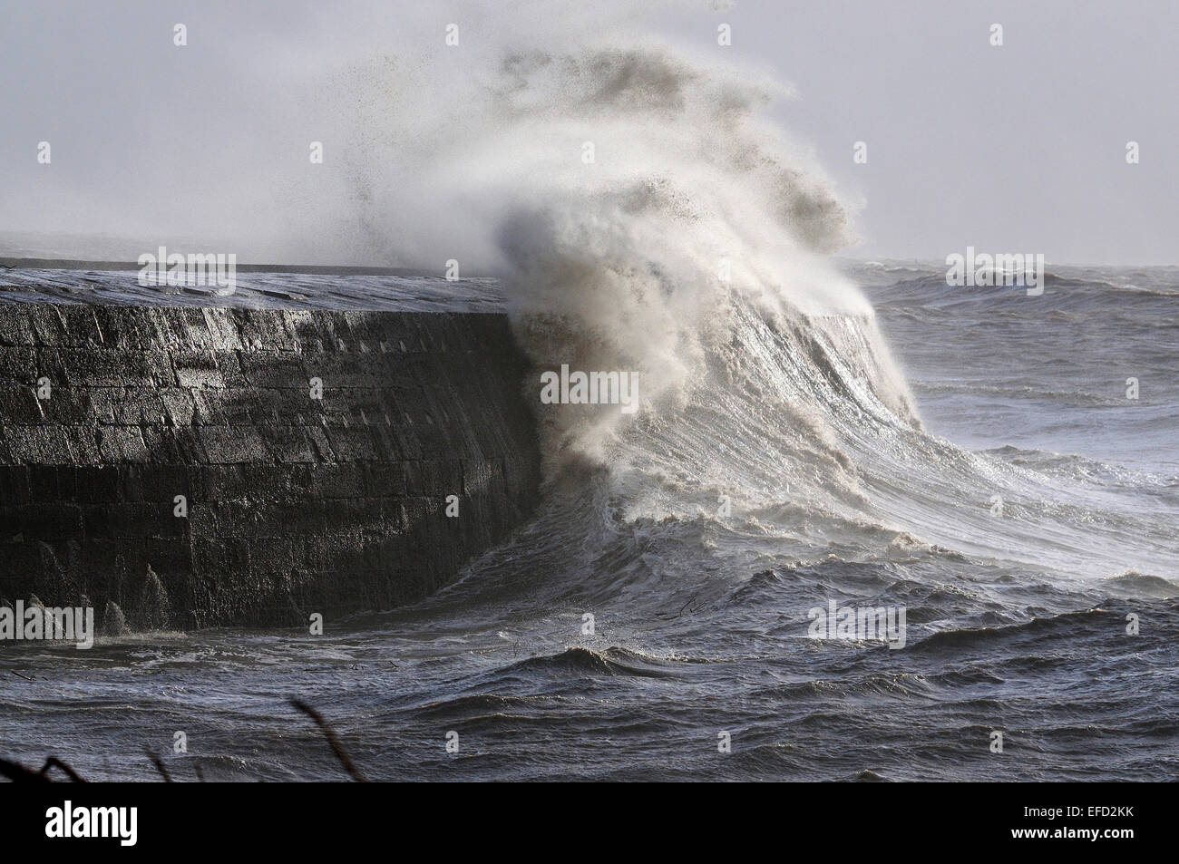 The Cobb, Lyme Regis, Dorset with waves crashing over it. Stock Photo