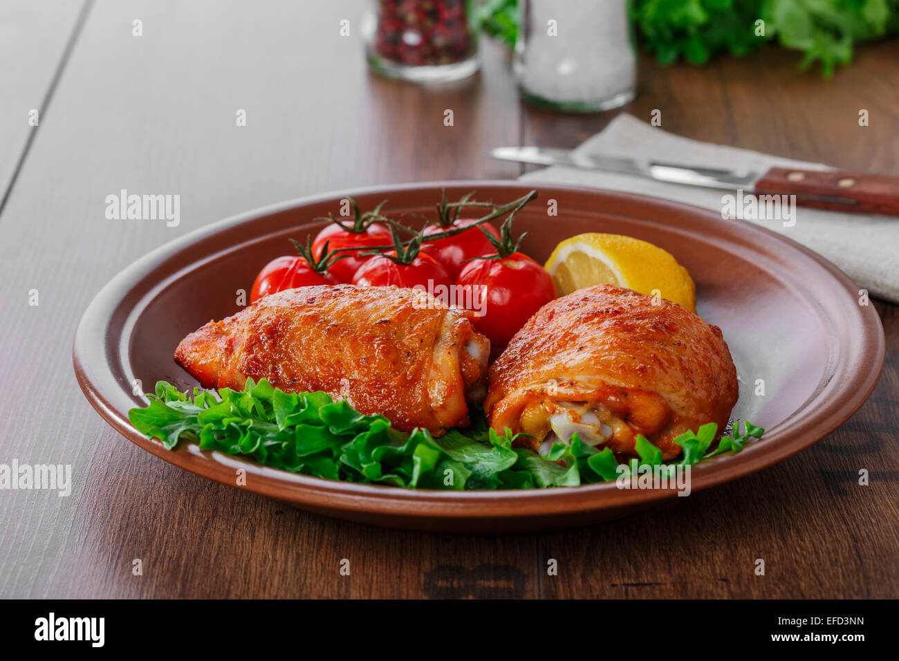 baked chicken thigh with cherry tomatoes and lemon Stock Photo