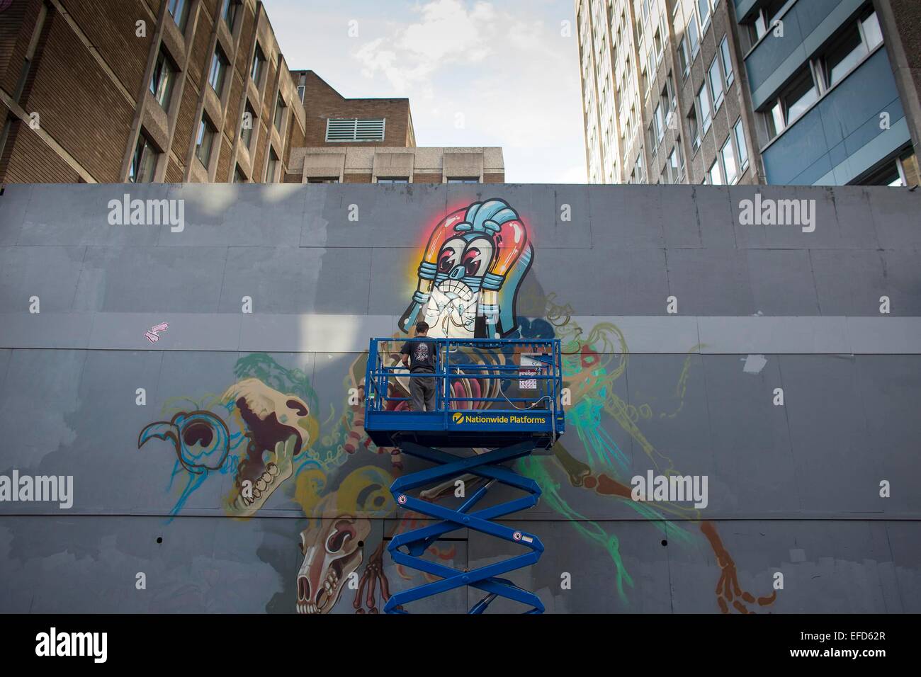 An artist works on a piece of urban street art and graffiti in Bristol