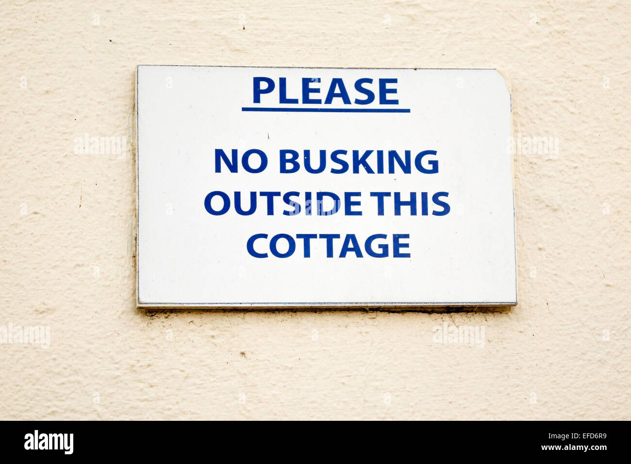 Sign outside a holiday cottage in busy Church Street Whitby Please no Busking Outside this Cottage Stock Photo