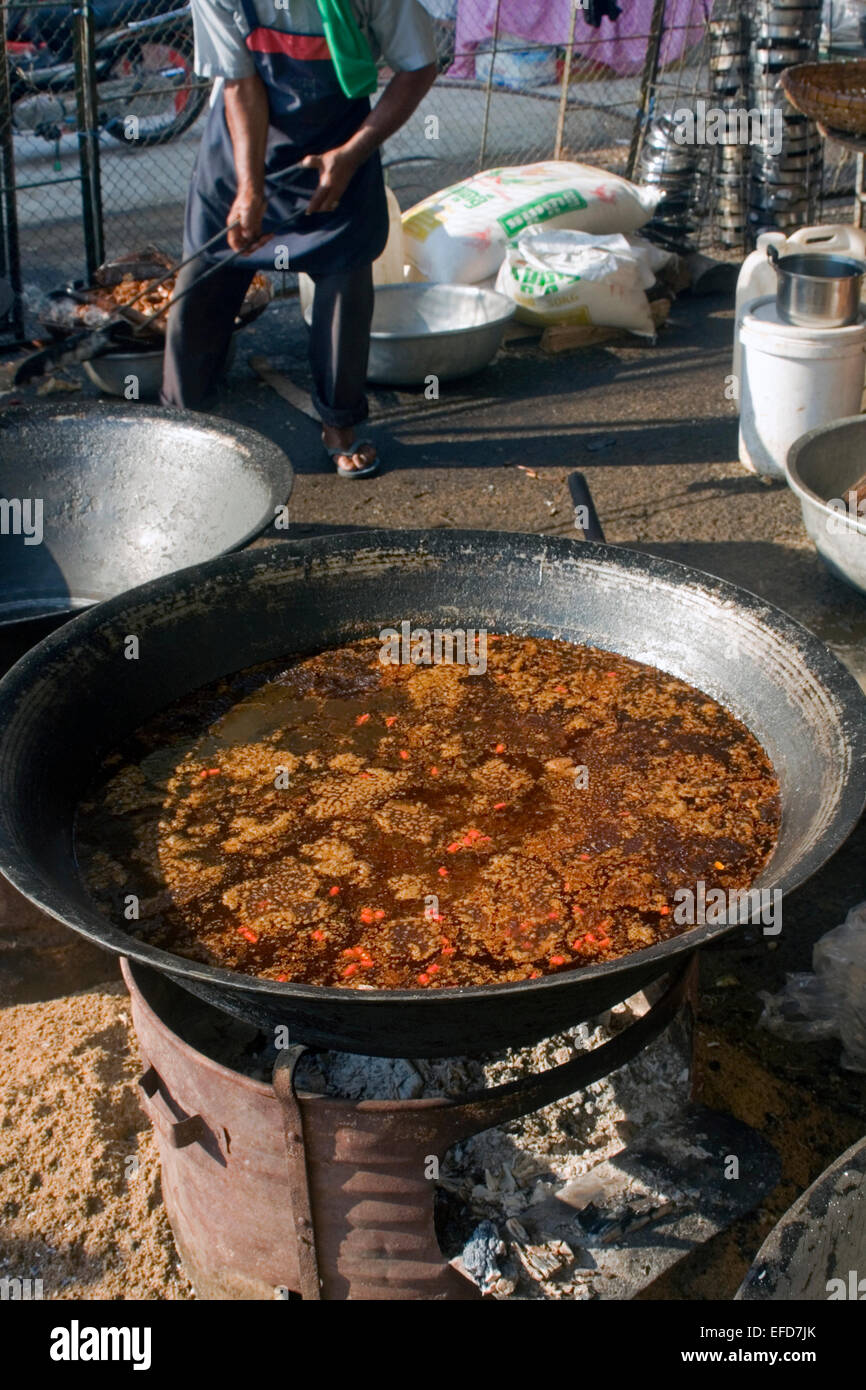 Broth used to spice street food is cooking in a large vat on a city street in Kampong Cham, Cambodia. Stock Photo