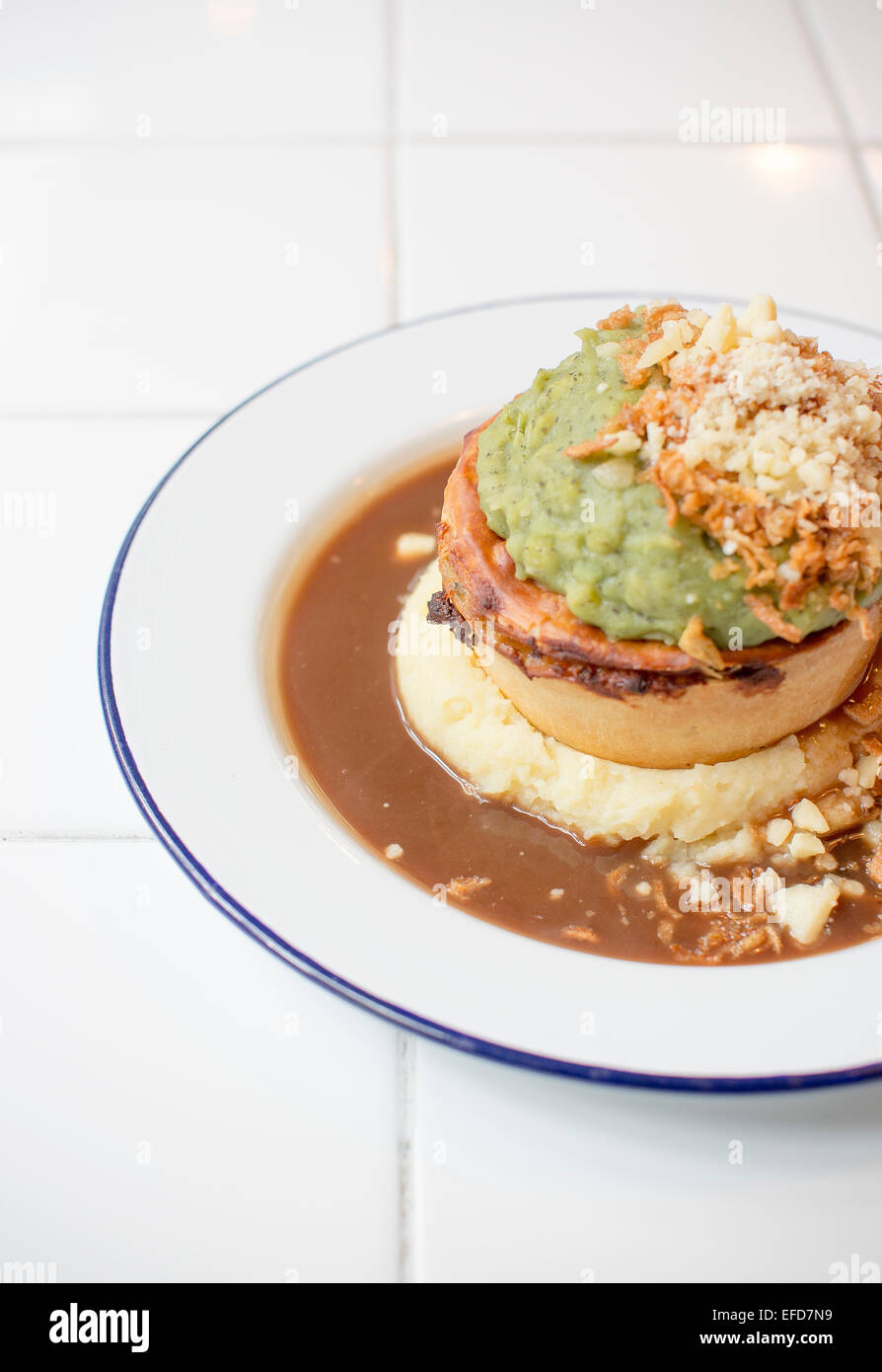 Pieminister pie served with mashed potato, mushy peas, onions and