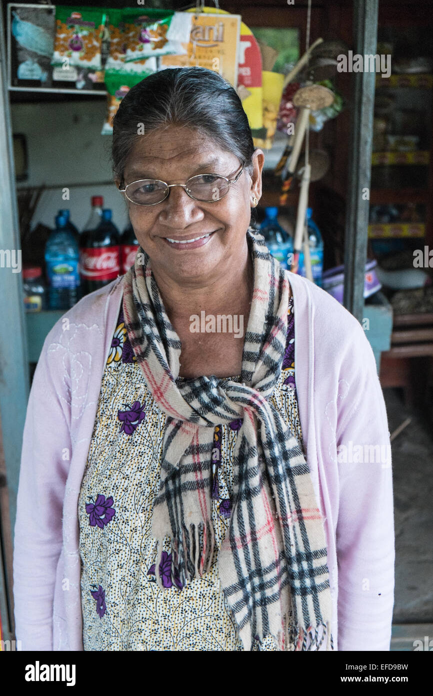 Local woman with Burberry scarf at her general store shop near train station at  Ella,Highlands,Sri Lanka,South Asia,Asia. Stock Photo