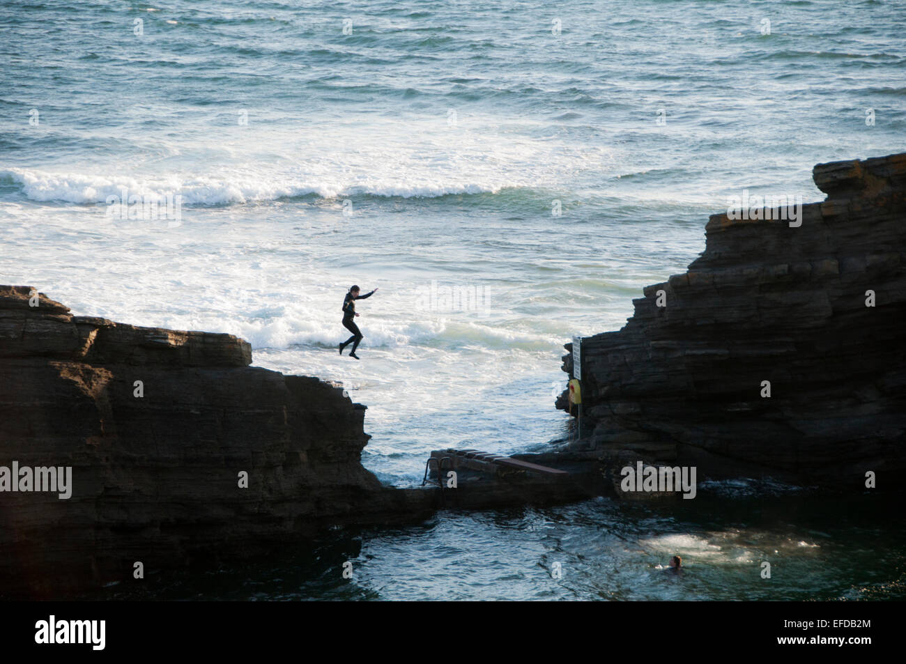 Young men jumping off the cliffs of Bundoran into the sea, in Donegal Ireland Stock Photo