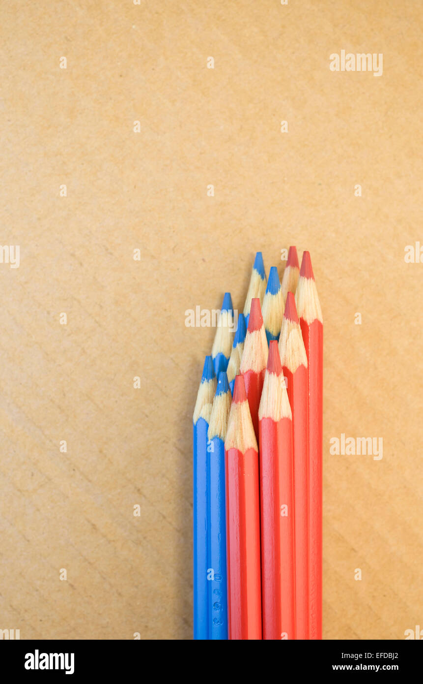 red blue colored crayons close up on a blurred light paperboard ...