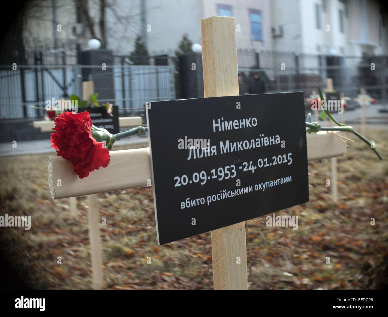 Crosses placed by activists and bearing the names of 30 people who died in shelling in Mariupol on Jan, 24 are seen in the foreground a cross with a sign that says 'Lily Nimenko, killed by Russian occupiers' near the Russian Embassy in Kiev, Ukraine, Sunday, Feb. 1, 2015. Stock Photo