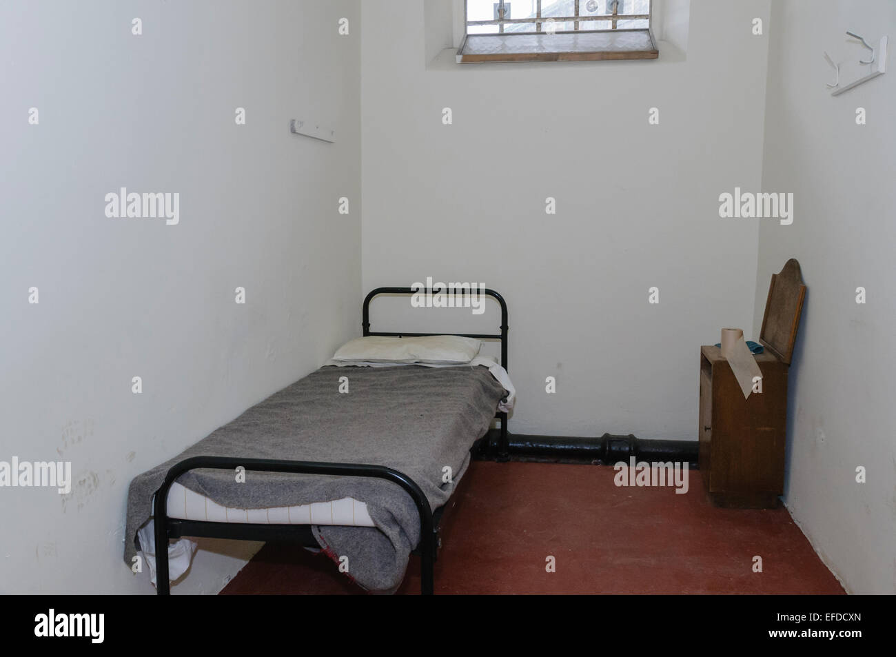 Bed and washstand in a small jail cell Stock Photo Alamy