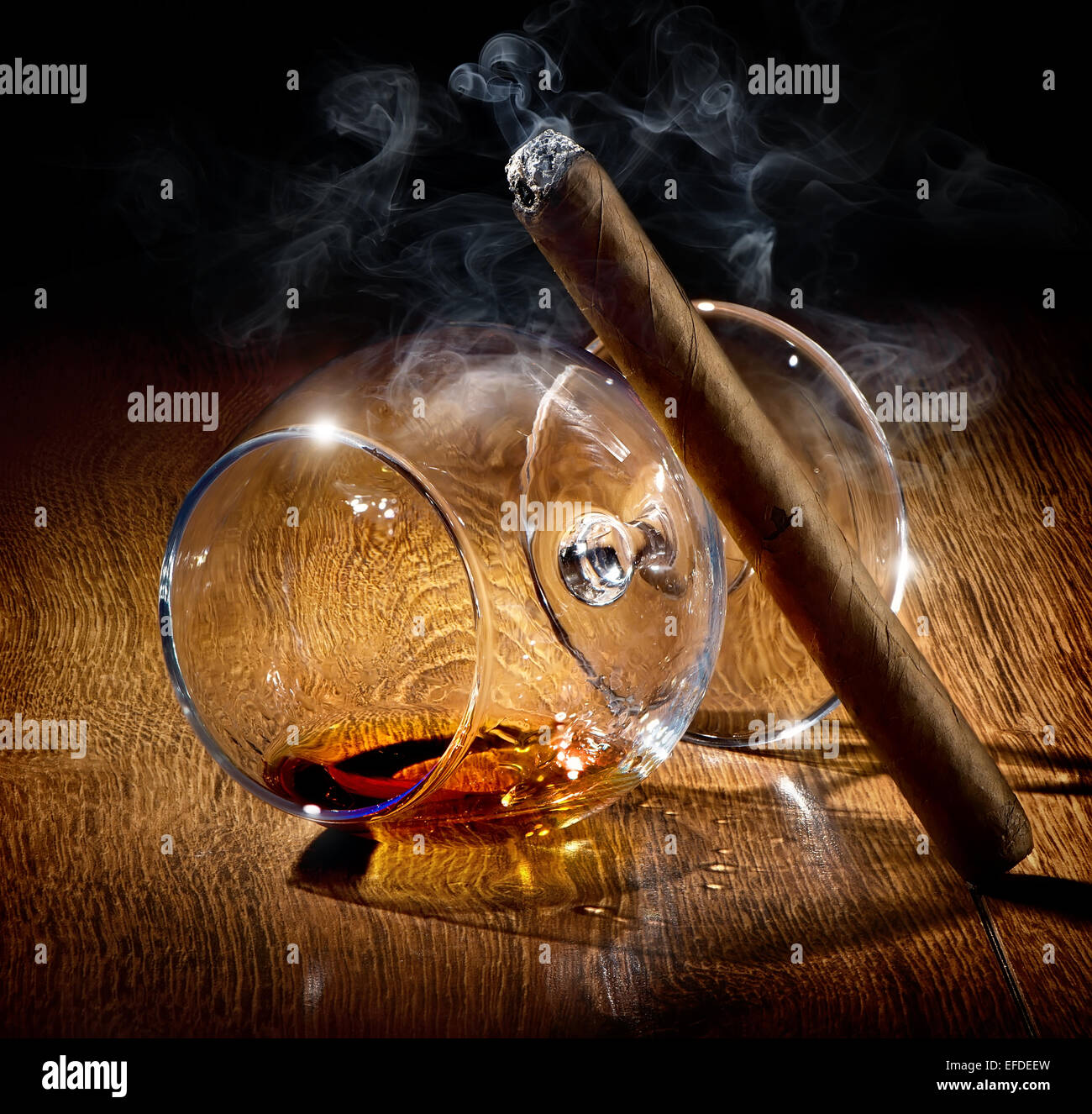Cigar and almost empty glass of cognac Stock Photo