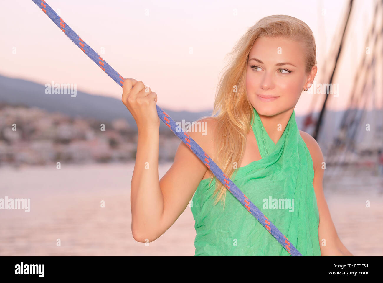 Romantic sea cruise, portrait of cute blond girl enjoying evening traveling on luxury sail boat, summer holidays concept Stock Photo