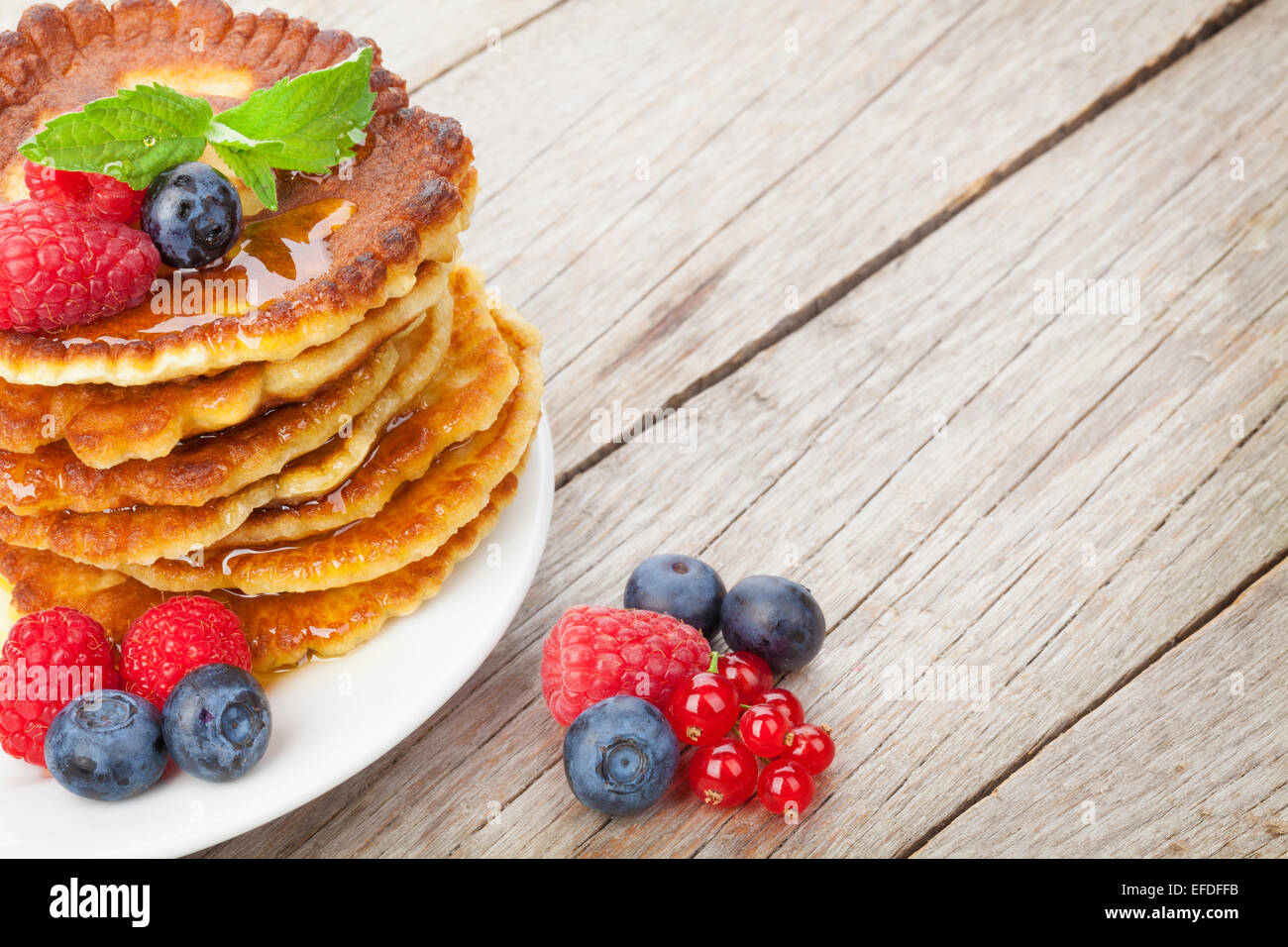 Pancakes Raspberry Blueberries Mint Pancakes with raspberry, blueberry, mint and honey syrup. On wooden ...