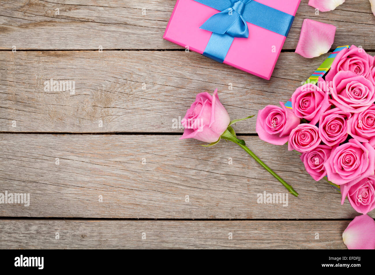 Valentines day background with gift box full of pink roses over wooden ...